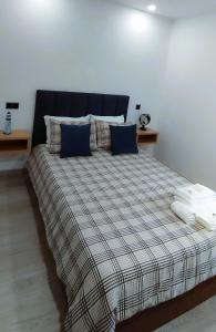 a bedroom with a large bed with a plaid blanket at Pinhal Litoral in Marinha Grande