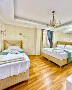 two beds in a room with wooden floors and a chandelier at Sultanahmet life suites apartment in Istanbul