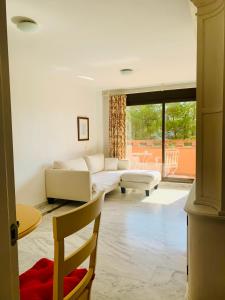een woonkamer met een witte bank en een raam bij Apartamento Milla De Oro Marbella in Marbella