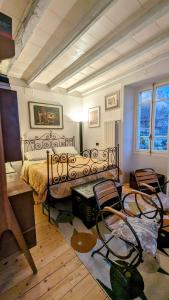 a bedroom with a bed and two chairs in it at Ratto del Gallo in Stresa