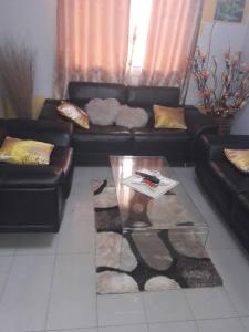 a living room with a couch and a coffee table at appartement meublé à Yansoki douala in Ngori