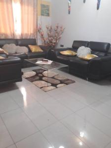 a living room with two couches and a glass table at appartement meublé à Yansoki douala in Ngori