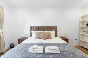 1 dormitorio con 1 cama con toallas en Cozy One-Bedroom Retreat in Morden SM4, London en Morden
