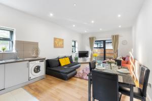uma cozinha e sala de estar com uma mesa e um sofá em Cozy One-Bedroom Retreat in Morden SM4, London em Morden