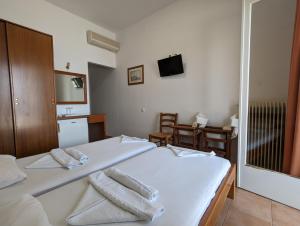 1 dormitorio con 1 cama con sábanas blancas y toallas en HELEN'S ROOMS, en Míloi