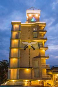 ein hohes Gebäude mit seitlicher Beleuchtung in der Unterkunft Hotel Task International in Pokhara