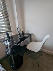 uma cadeira branca e uma secretária num quarto em 2 bedroom apartment in Gravesend 10 mins walk from train station with free parking em Gravesend