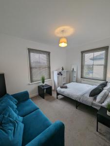 een woonkamer met een bank en een bed bij 2 bedroom apartment in Gravesend 10 mins walk from train station with free parking in Gravesend