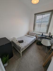 a bedroom with a bed and a desk and a window at 2 bedroom apartment in Gravesend 10 mins walk from train station with free parking in Gravesend