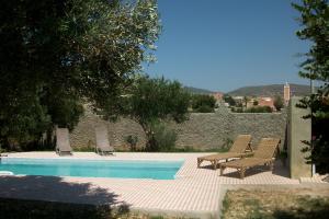 a swimming pool with two chairs and avisorvisor at RIAD BERBERE in Taghazout