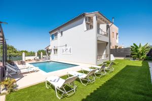 a villa with a swimming pool and lawn at Villa Artemis A&B in Chania Town