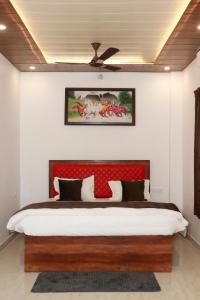a bedroom with a large bed with a red headboard at Sun River Resort in Dogadda
