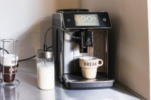 eine Kaffeemaschine mit einer Tasse mit dem Wort Break drauf in der Unterkunft Flytosuite Aeroporto Penthouse Attic Room in Calderara di Reno