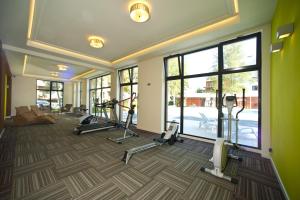 a gym with treadmills and ellipticals in a room with windows at Apartamenty BalticON Polanki in Kołobrzeg