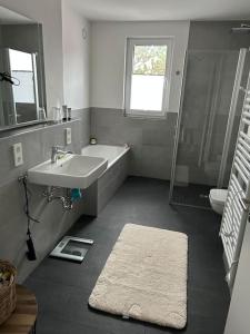 ein Badezimmer mit einem Waschbecken, einer Badewanne und einer Dusche in der Unterkunft Exklusive Penthouse-Wohnung mit Blick über Marburg in Marburg an der Lahn