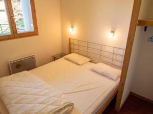 een bed met twee kussens in een slaapkamer bij Appartement Valfréjus, 2 pièces, 6 personnes - FR-1-468-65 in Valfréjus