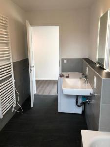 a bathroom with a white sink and a door at Exklusive Penthouse-Wohnung mit Blick über Marburg in Marburg an der Lahn