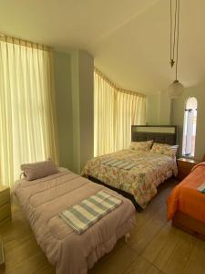a bedroom with two beds and a window at Casa familiar in Tacna +8 photos