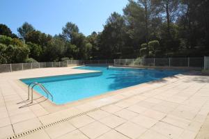 een zwembad met blauw water in een tuin bij Valbonne - Villa dans le domaine privé Val d'Azur avec piscine, tennis in Valbonne