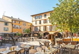 een openluchtrestaurant met tafels, stoelen en gebouwen bij Valbonne - Villa dans le domaine privé Val d'Azur avec piscine, tennis in Valbonne