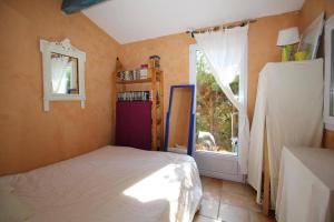 een slaapkamer met een bed en een groot raam bij Valbonne - Villa dans le domaine privé Val d'Azur avec piscine, tennis in Valbonne