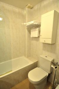 y baño con aseo, lavabo y bañera. en Hotel Apartamentos Aralso Sotillo en La Lastrilla