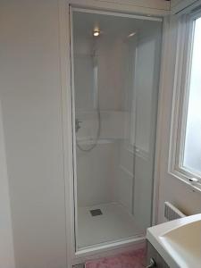 baño blanco con ducha y lavamanos en La Bourgogne en Alsace - charmant séjour familial, en Munster