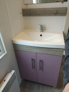 baño con lavabo púrpura y espejo en La Bourgogne en Alsace - charmant séjour familial, en Munster