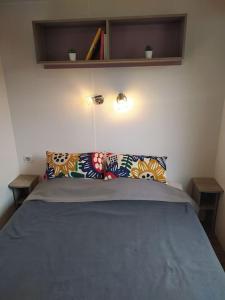 1 dormitorio con 1 cama azul y 2 almohadas en La Bourgogne en Alsace - charmant séjour familial, en Munster