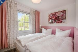 une chambre avec deux lits et une fenêtre dans l'établissement Ferienresort Möwenort Lütow Bungalow 8, à Lütow