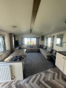 ein Wohnzimmer mit einem Sofa und einem Tisch in der Unterkunft Atlas festival in Leysdown-on-Sea