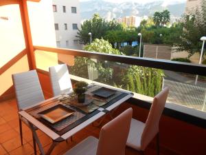 een balkon met een tafel en stoelen en uitzicht bij Jardinas de les Marinas in Denia