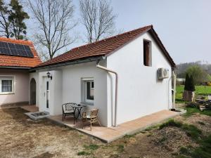 a small white house with a wooden deck at Haus Yuphin in Hart bei Graz