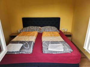 Bett in einem Zimmer mit zwei Kissen darauf in der Unterkunft Haus Yuphin in Hart bei Graz