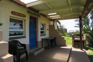 een veranda van een huis met een tafel en stoelen bij Coffee Shack Adventure Backpackers & Self-Catering in Coffee Bay
