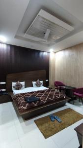 1 dormitorio con 1 cama grande y sillas moradas en Swastik Vatika en Ambāla