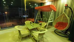 um quarto com uma mesa e cadeiras e um baloiço em Swastik Vatika em Ambala