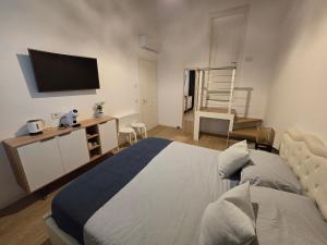 - une chambre avec un lit et une télévision à écran plat dans l'établissement Tre Lati b&b, à Case del Bevano