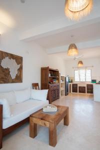 a living room with a white couch and a coffee table at Rafiki Tamu Residential Resort in Watamu