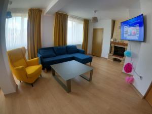 een woonkamer met een blauwe bank en een tafel bij Casa Bear Azuga in Azuga