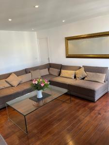 - un salon avec un canapé et une table en verre dans l'établissement bel appartement chic et cosy 78100, à Saint-Germain-en-Laye