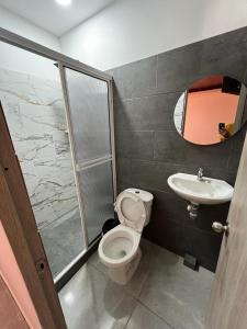 a bathroom with a toilet and a sink at Hotel Almalu in Aguachica