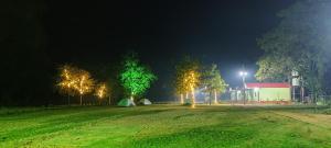 un campo con una tienda y árboles por la noche en SIMILIPAL NATURE RETREAT en Bālidiha