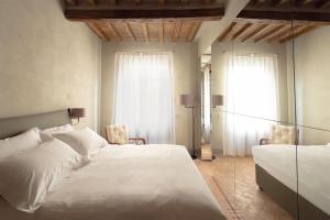 1 dormitorio con 2 camas blancas y ventana en Locanda La Concia, en Reggio Emilia