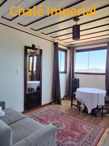 a living room with a table and a mirror at Chalé Mirante do Sol in Ouro Preto