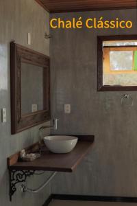 a bathroom with a sink and a mirror at Chalé Mirante do Sol in Ouro Preto