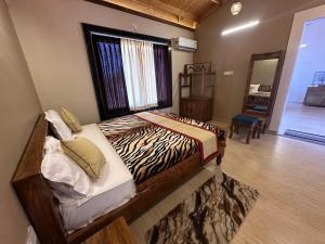 a bedroom with a zebra print bed with a window at NATURE NEST HOMESTEAD in Baihar
