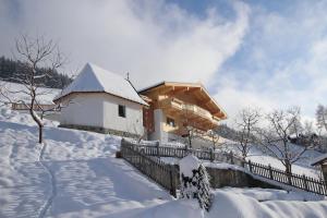 uma casa está coberta de neve com uma cerca em Ferienwohnung Bergpanorama WILD600 em Auffach