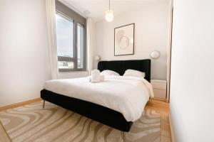 a bedroom with a large bed with white sheets at Modern 2BR in Central Luxembourg Near Old Town in Luxembourg