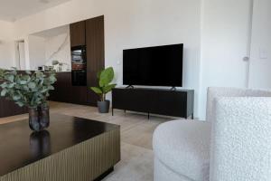 uma sala de estar com uma televisão de ecrã plano e uma mesa em City Elegance in Historic Ville-Haute ID173 em Luxemburgo